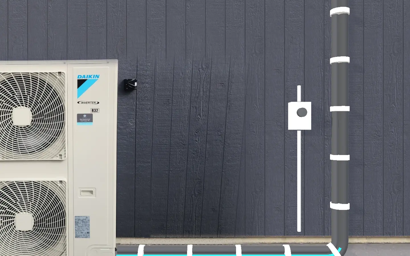The lagged pipe pair running from the outdoor unit along the cladding to where it enters the wall